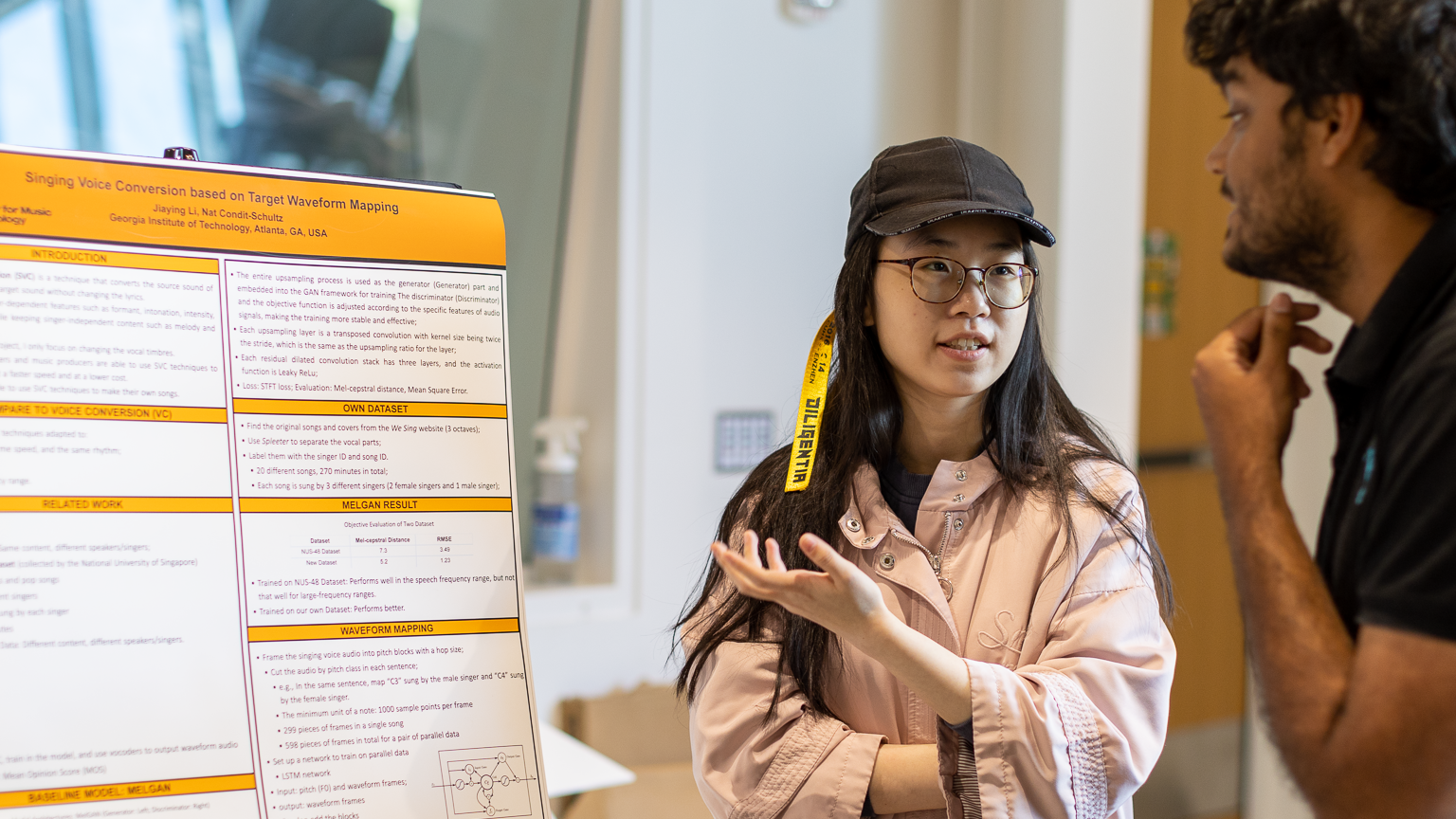Jiaying Li in front of a research poster, talking to another student