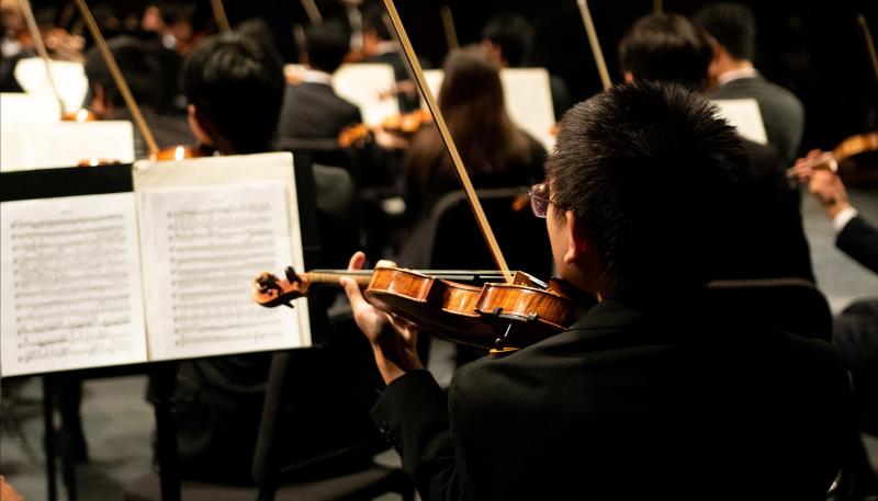 A violinist plays with the symphony orchestra